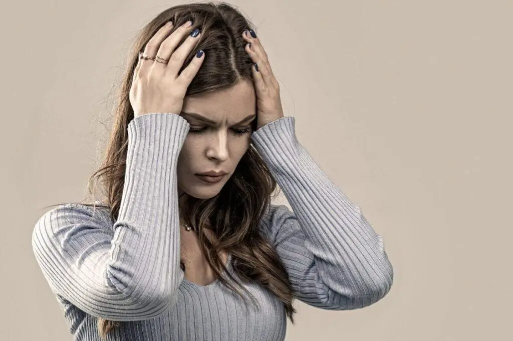 kobieta zmagajaca sie z objawami adhd u doroslych trzyma glowe w dloniach