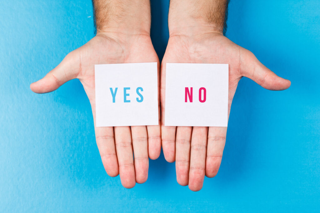 Dłonie trzymające kartki z napisem yes i no – symbol asertywności i wyznaczania granic