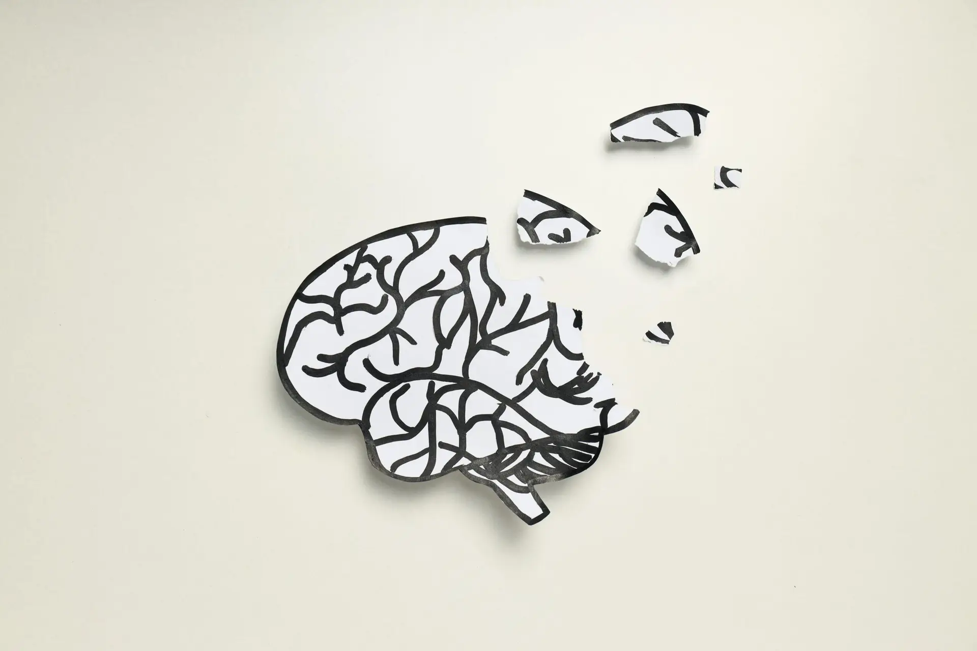 symboliczna ilustracja głowy z fragmentami mózgu oddzielonymi od całości jako metafora ADHD i trudności z koncentracją