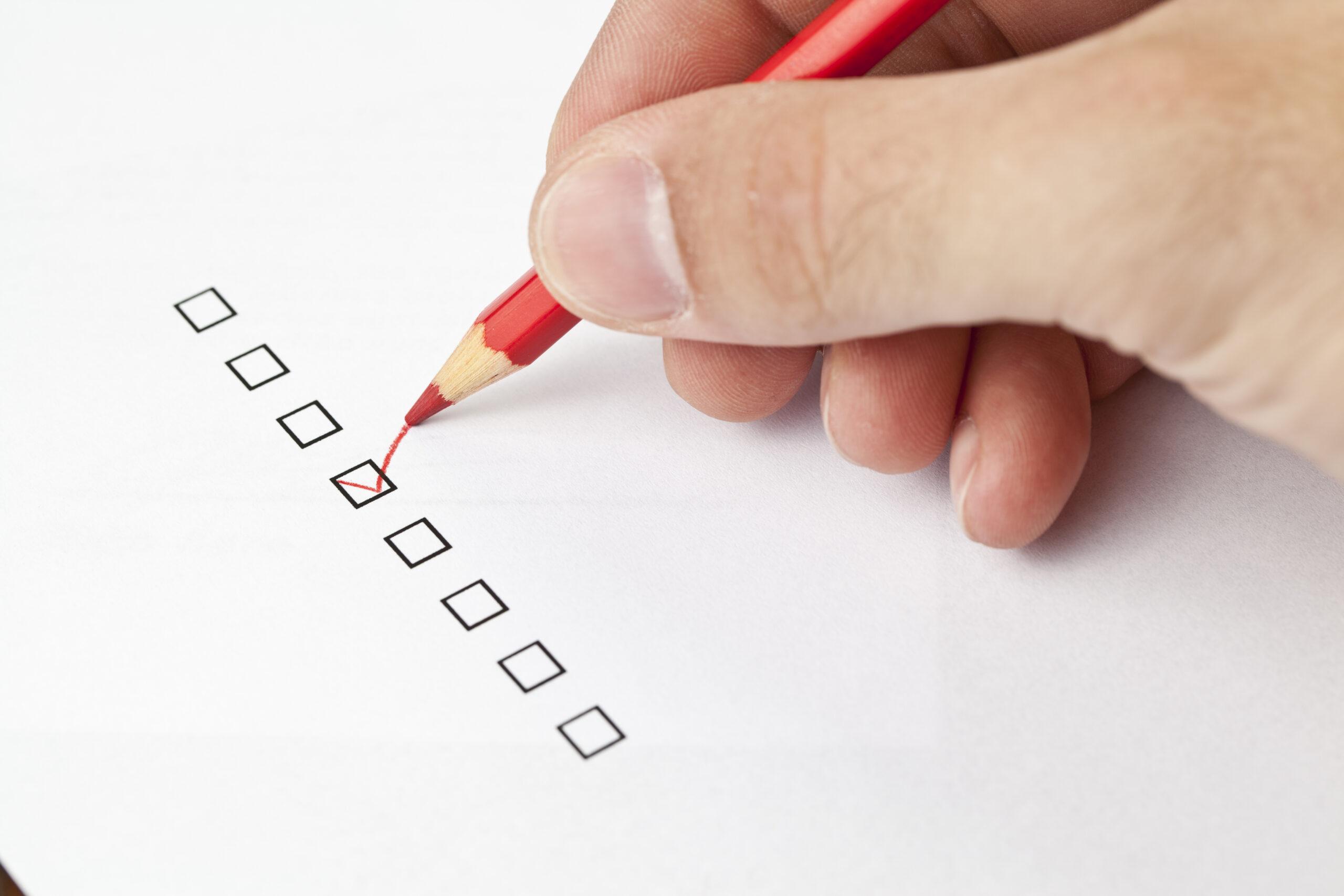 czerwony ołówek zaznaczający pole na liście kontrolnej – planowanie zadań i organizacja w ADHD