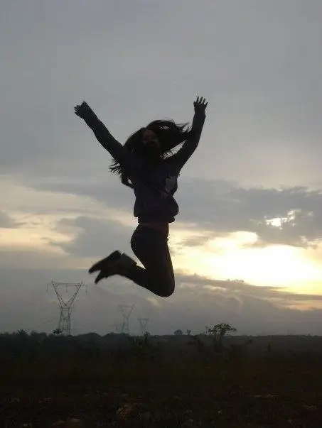 Osoba skacząca w powietrzu na tle zachodu słońca, pełna energii i spontaniczności