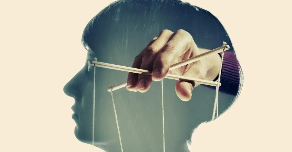 Sylwetka głowy z widocznymi sznurkami manipulacji, symbol kontroli i wpływu w relacji