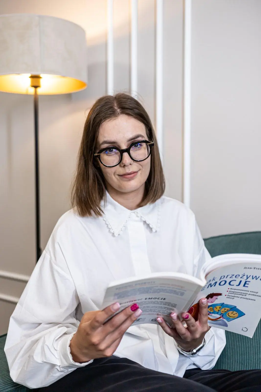 Aleksandra Pomagier – psycholog Centrum Optimus w Poznaniu, czytająca książkę w gabinecie